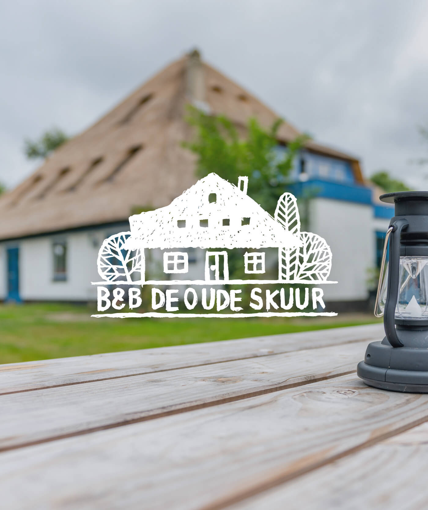 Rietgedekt huis met een houten tafel en een lantaarn op de voorgrond. De tekst overlay luidt B&B DE OUDE SKUUR met een schets van een huis en bomen. Perfecte inspiratie voor websites of online diensten gericht op gezellige retraites.